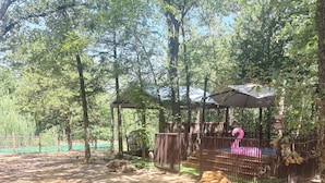 A wooden gazebo with a roof, surrounded by trees. - Four 6666 - Come experience a sleepover with our Giraffe, Puzzles and Jigsaw! (Valley View)