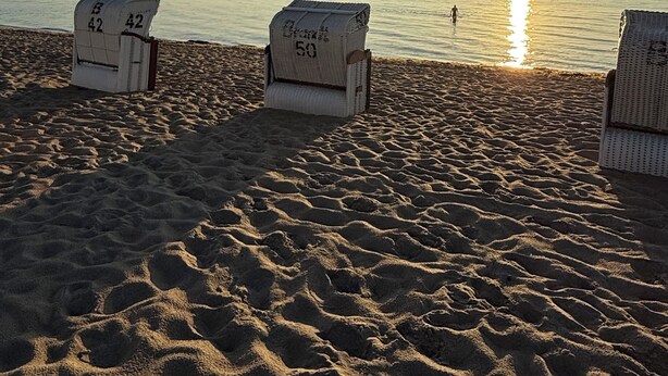 Une plage avec trois transats, chacun portant un numéro.