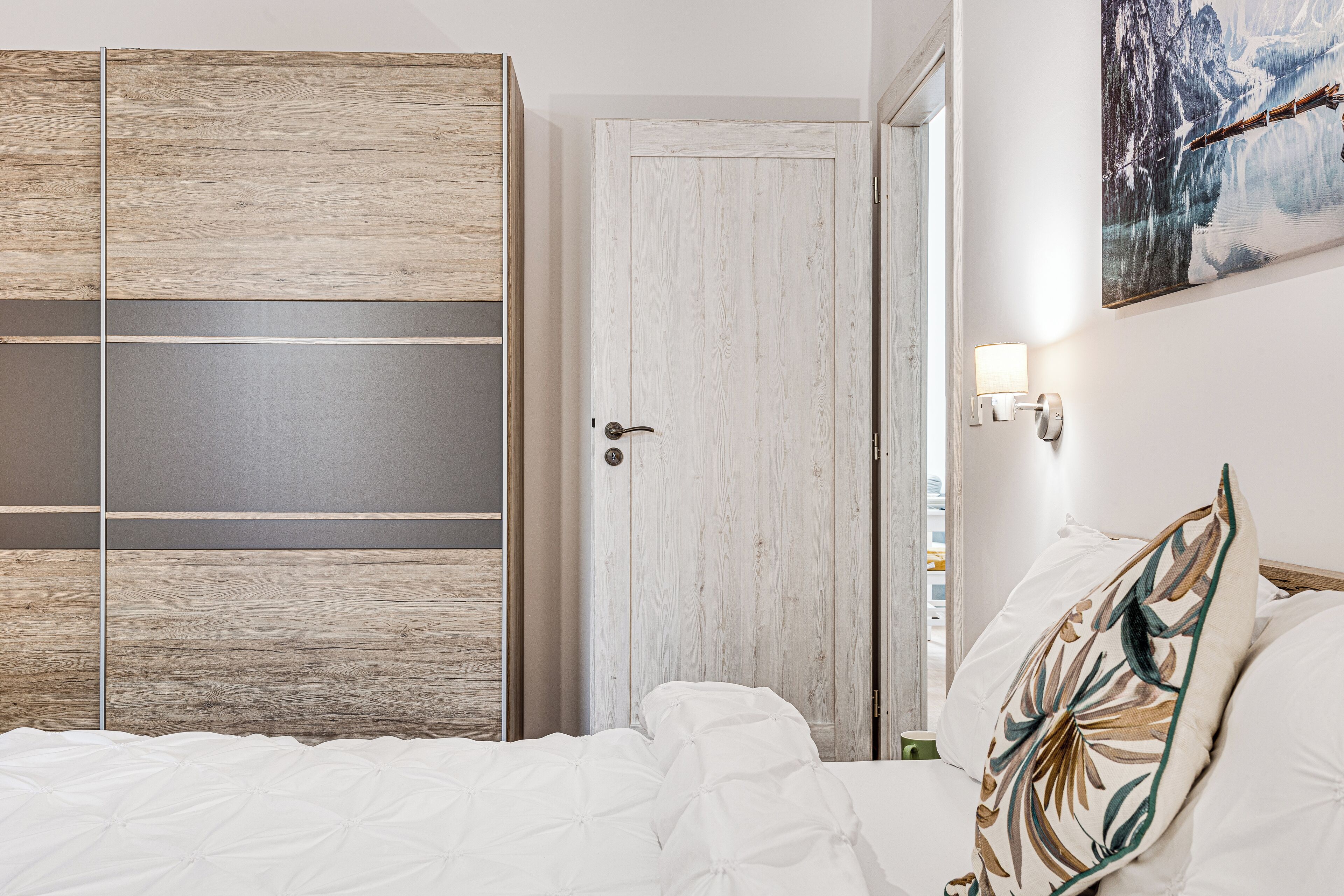 Un dormitorio con cama, armario y puerta.