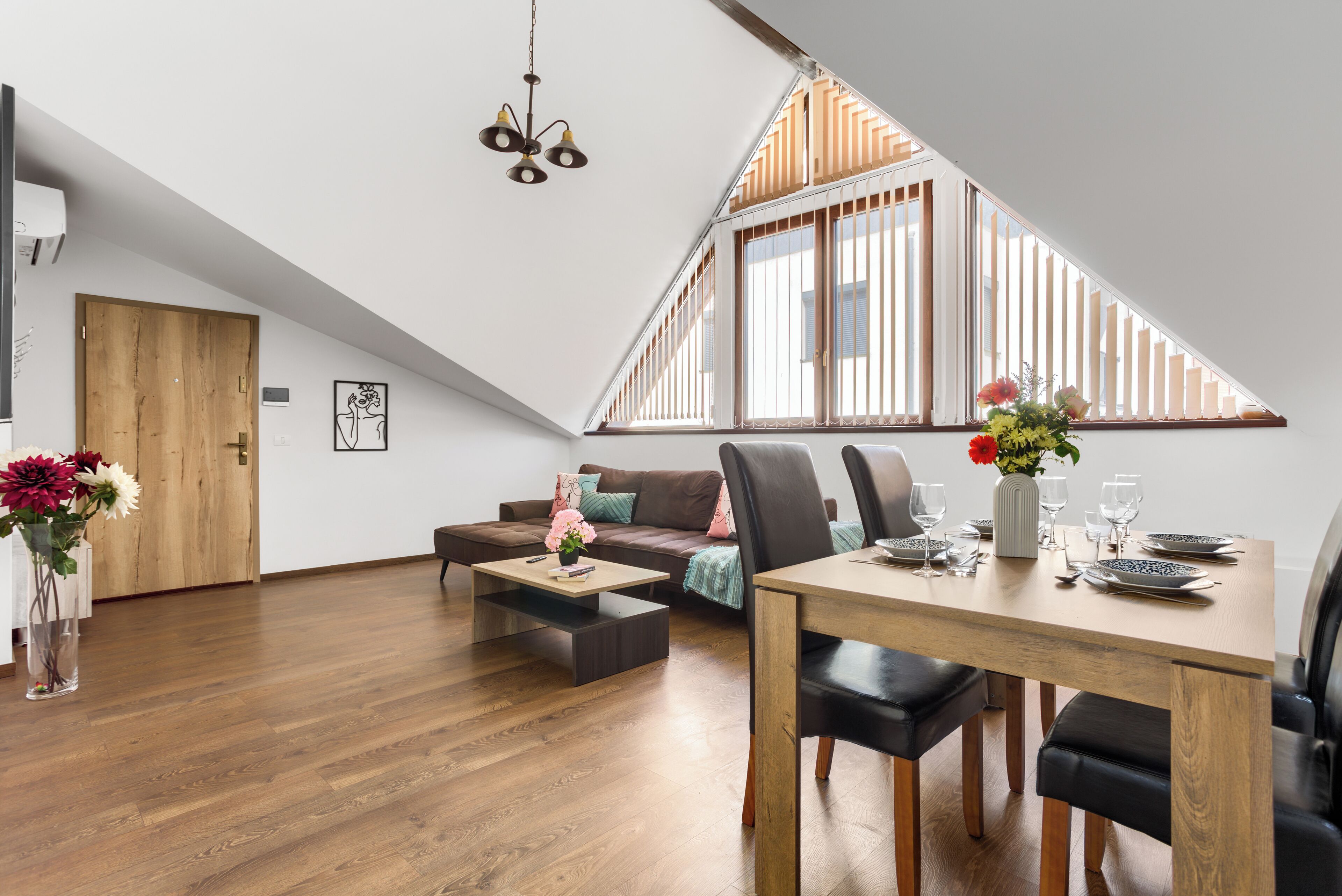 Un loft moderno con comedor, sofá y piso de madera.