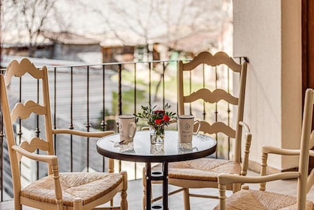 A round table with two chairs, a vase with flowers, and two mugs on the table.. ARI Central Grand Apartments-Luxury Stay
