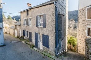 Una calle estrecha con edificios antiguos, una puerta a la vista y una escalera que sube a un nivel superior.