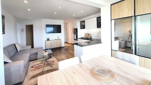 A modern apartment with a living room, dining area, and kitchen. - A serene stay with a sea view (Grosseto-Prugna)