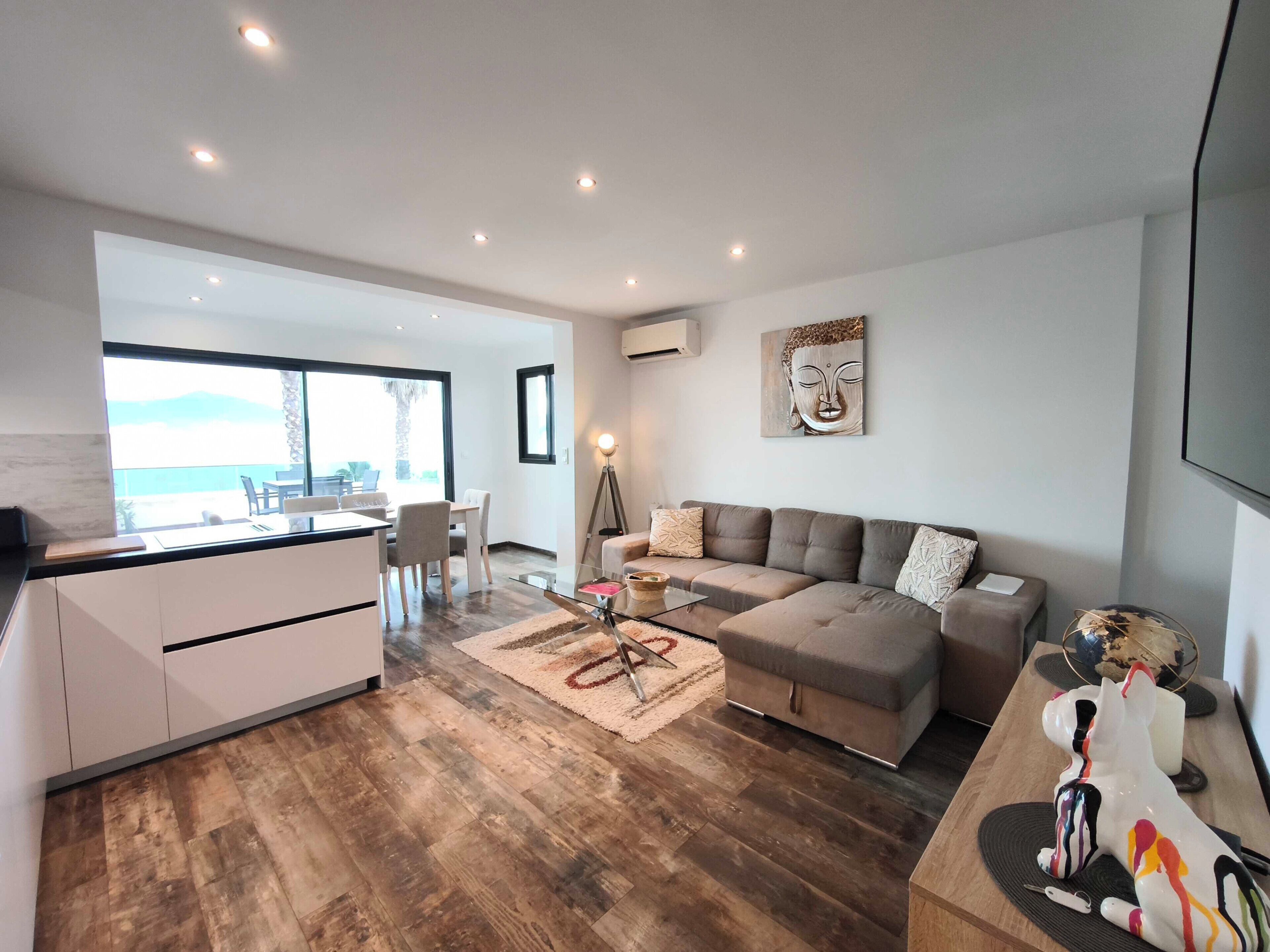 Un espacio habitable moderno con cocina, comedor y un amplio ventanal con vistas.