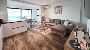 A modern living space with a kitchen, dining area, and a large window offering a view. - A serene stay with a sea view (Grosseto-Prugna)