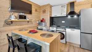 A compact kitchen with a microwave, stove, and refrigerator.