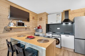 A compact kitchen with a microwave, stove, and refrigerator. - Studio "Mbs Pra Loup" with Mountain View, Balcony and Wi-Fi (Uvernet-Fours)