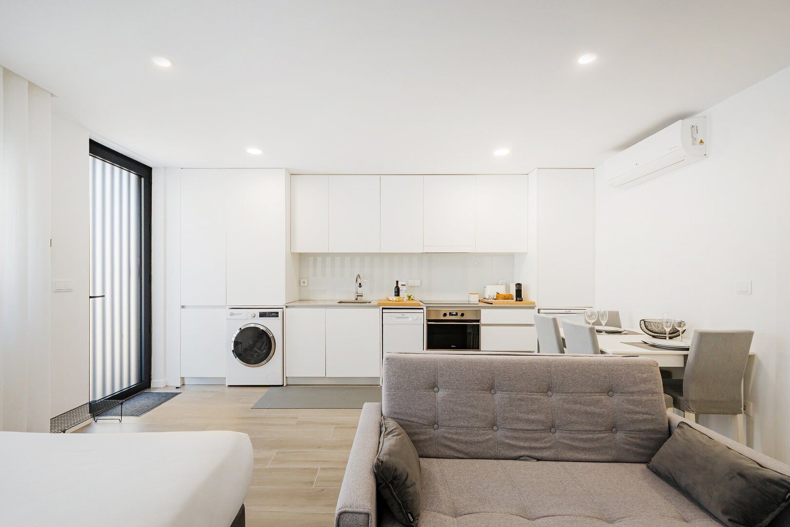 Un apartamento moderno con cocina, comedor y sala de estar con sofá.