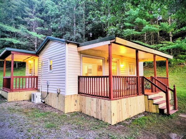 Two wooden cabins with attached porches, surrounded by a forest. - Fiddlers Lake Cabin, Galax Va, Fishing, New River Trail, Fancy Gap, Mountains  (Galax)