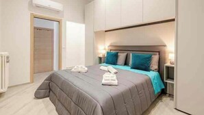 A modern bedroom with a large bed, a bedside table, and a wardrobe. - Guest House San Giacomo*Holidays in Apulia* in the centre to 5 min Teatro Curci (Barletta)