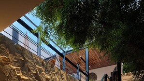 A staircase with stone walls and a metal railing, leading to an upper level. - Hotel Compatir (Santa María Colotepec)