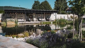 A modern outdoor pool area with lounge chairs and a pergola. - Hotel FREIGOLD (Freistadt)