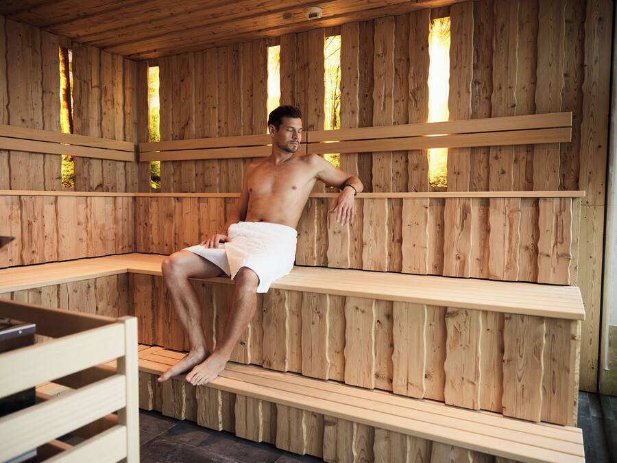 A wooden sauna with benches and a table.