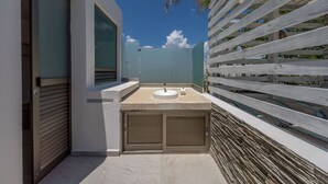 Een moderne badkamer met een vrijstaand badkamermeubel, een deur en uitzicht op de lucht.