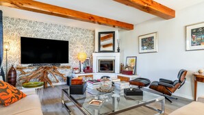 A living room with a television, fireplace, and modern furniture.