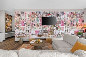 A modern living room with a large wall collage, a flat-screen TV, a sofa, and a coffee table. - 2BR Music Theme in Music City - 8min to Broadway (Nashville)