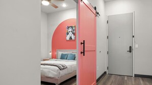 A bedroom with a bed, a pink door, and a white door. - Chic 2BR Getaway in Downtown Nashville! (Nashville)