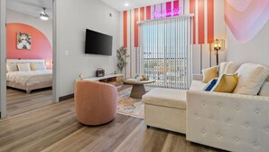 Ein modernes Wohnzimmer mit einem Bett, einem Sofa, einem Couchtisch und einem Fernseher.