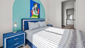 A bedroom with a bed, nightstands, a blue arched wall, and a painting.