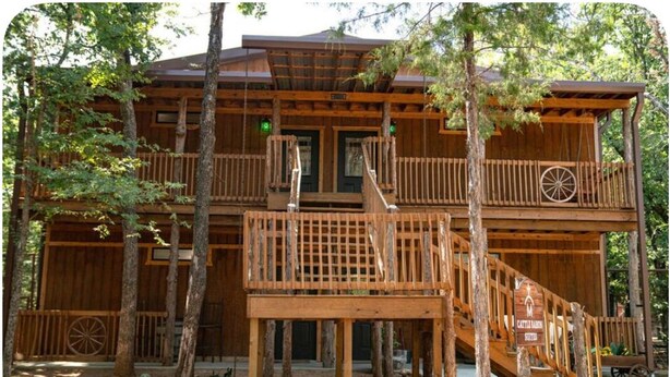 Eine zweistöckige Holzhütte mit Balkon und Treppe.