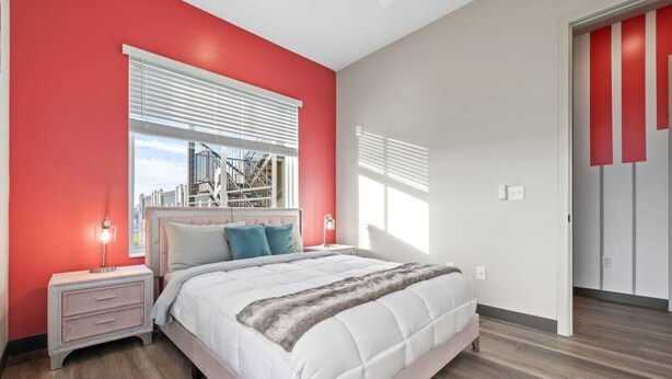 A bedroom with a bed, nightstands, a window with blinds, and a view of a building outside. - Perfect for Family Getaway - Mins from Music City! (Nashville)