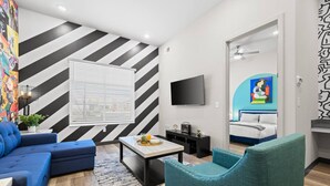 A modern living room with a sofa, armchair, and a flat-screen TV.