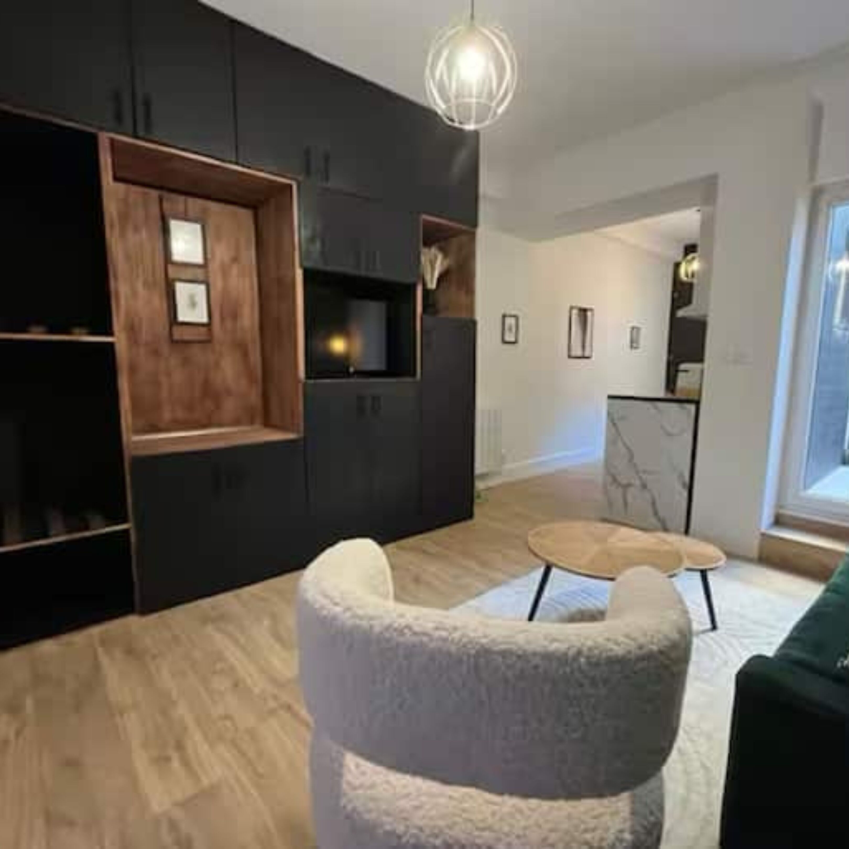 A modern living room with a sofa, a round coffee table, and a TV.