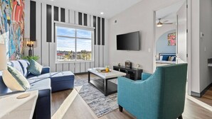 A modern living room with a sofa, a coffee table, and a TV.
