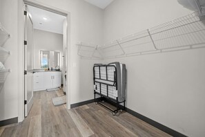 Een wasruimte met een droogrek, een inloopkast en een houten vloer.