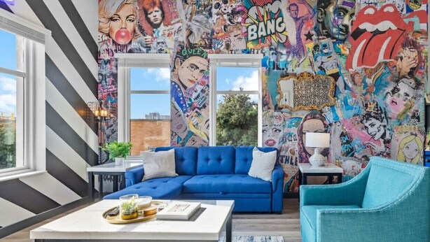 A living room with a blue sofa, a coffee table, and a teal armchair.