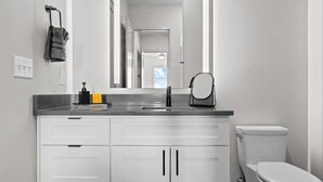 A modern bathroom with a white vanity, a black faucet, and a toilet. - Trendy Oasis: 8 Min to Broadway, Sleeps 4! (Nashville)