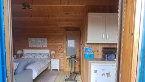 A cozy cabin interior with a bed, a small kitchenette, and a bathroom. - Cute cosy and chilled cabin in lahinch (Lahinch)