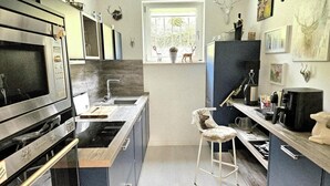 Eine moderne Küche mit Edelstahlgeräten, einem Fenster und dekorativen Geweihen an der Wand.