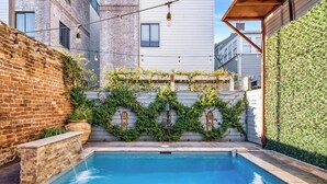 A swimming pool with a brick wall and a white building in the background. - Sunny 5BR Villa w/ Heated Pool & Courtyard Oasis (New Orleans)