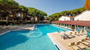 A swimming pool with lounge chairs and a water feature. - Vacation village Jesolo Lodge Comfort for 5 persons (Lido di Jesolo)