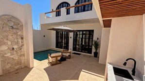 A modern house with a swimming pool, outdoor seating, and a stone wall. - 🌴Elegant Villa with Private Pool in Los Cabos☀️️ B.C.S, Mexico. (El Tezal)
