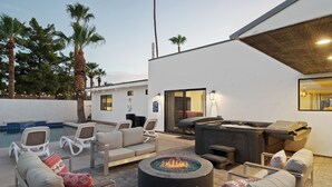 A modern outdoor patio with lounge chairs, a fire pit, and a pool. - Scottsdale Sunstone Villa, Modern 6BR w/ Private Pool & Spa, Walk to Old Town (Scottsdale)