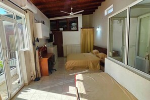 A bedroom with a bed, a desk, a chair, a ceiling fan, and a sliding glass door. - 1-bedroom cozy apartment in the heart of Colombo (Colombo)