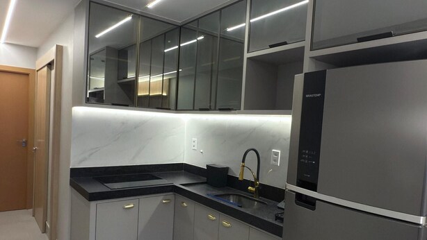 A modern kitchen with a stainless steel refrigerator, black countertops, and a built-in oven. - Magnificent apartment in an upscale neighborhood (Imperatriz)