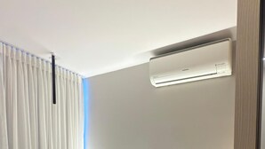 A modern hotel room with a bunk bed, a bedside table with a lamp, and a wall-mounted air conditioner. - Magnificent apartment in an upscale neighborhood (Imperatriz)