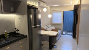A modern kitchen with a built-in refrigerator, a dining area with a table and chairs, and a sofa in the background. - Magnificent apartment in an upscale neighborhood (Imperatriz)