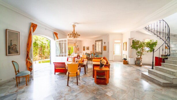 A spacious living room with a marble floor, a staircase, and a large potted plant. - Authentique Villa Tunisoise Avec Piscine Marsa (La Marsa)