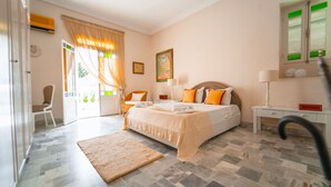 A bedroom with a bed, bedside tables, a chair, and a view of the outdoors. - Authentique Villa Tunisoise Avec Piscine Marsa (La Marsa)