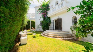 A white building with a covered outdoor seating area, steps leading to a gated entrance, and lush greenery surrounding the property. - Authentique Villa Tunisoise Avec Piscine Marsa (La Marsa)