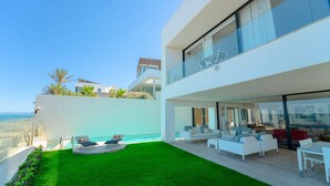 A modern two-story house with a rooftop pool, a well-maintained lawn, and a view of the ocean. - Villa Amaya Grand Luxe Face a la mer (La Marsa)