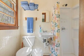 A bathroom with a toilet, sink, and shower curtain.