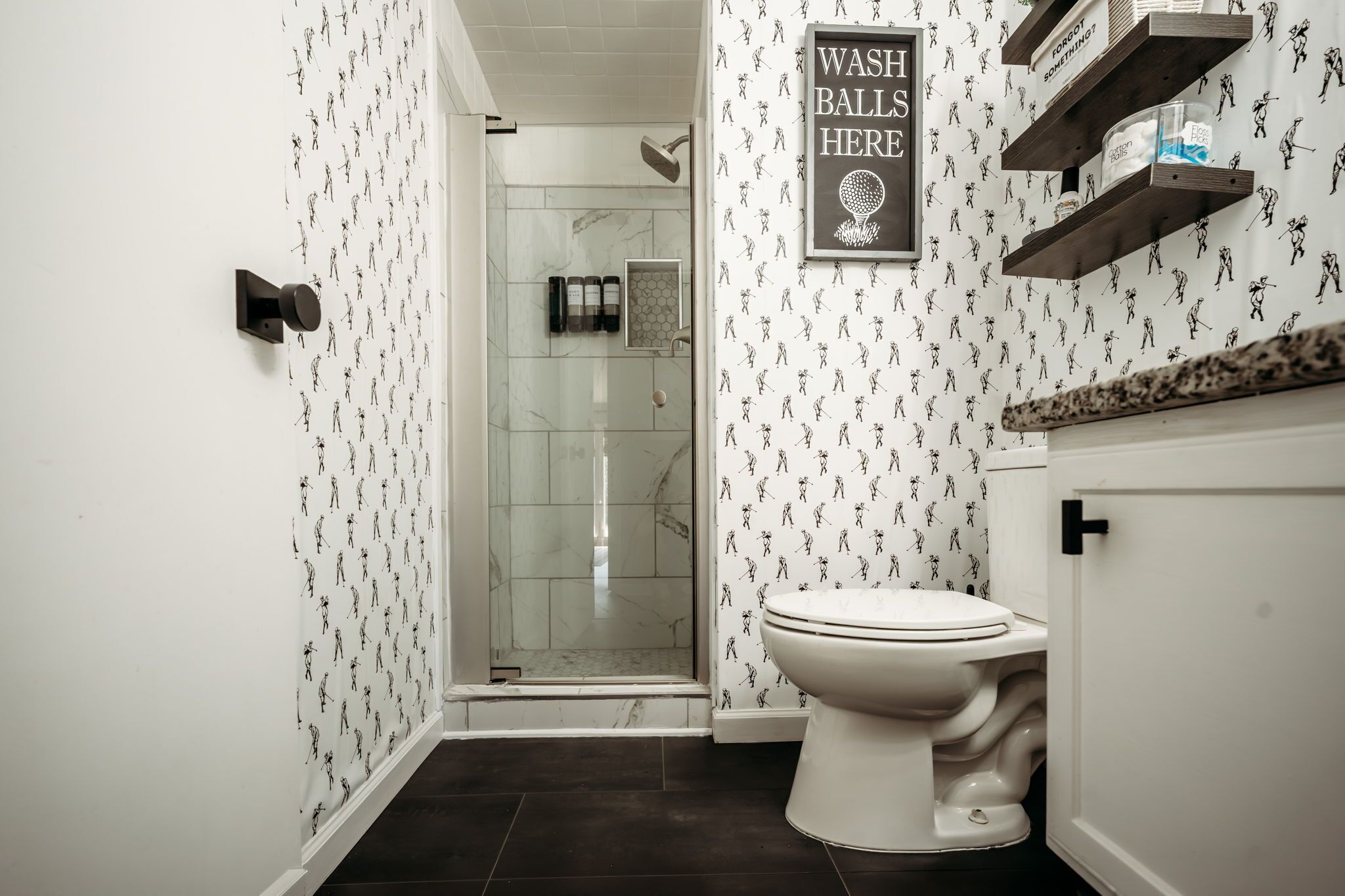 A bathroom with a shower, toilet, and a 'WASH BALLS HERE' sign.