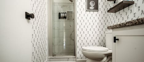 A bathroom with a shower, toilet, and a 'WASH BALLS HERE' sign.