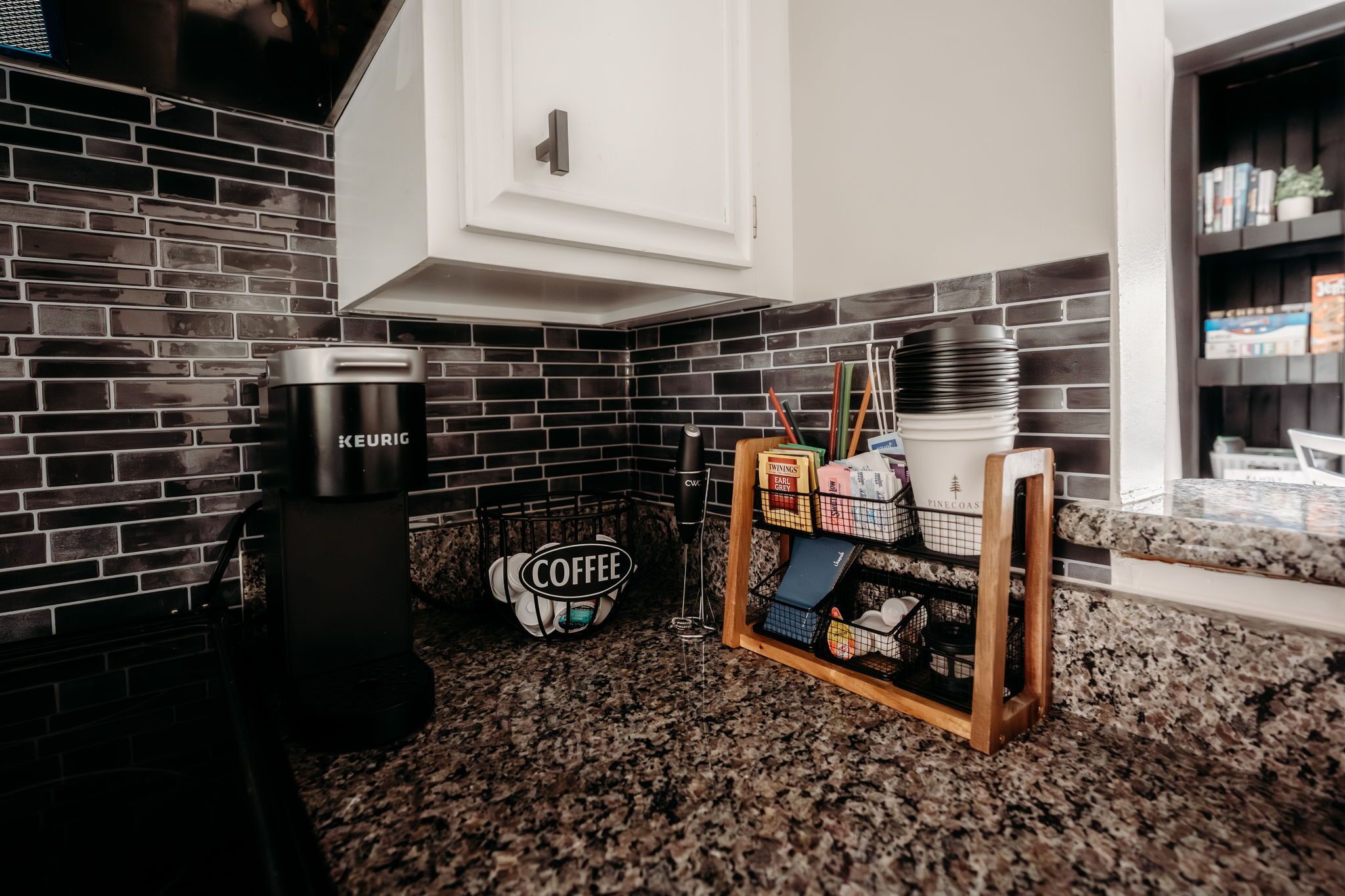 Een keuken met een koffiezetapparaat, koffie en een displayplank voor koffie.