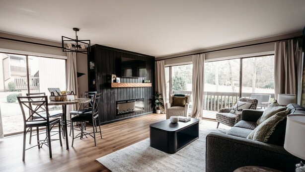 Una sala de estar moderna con chimenea, comedor y sofá.